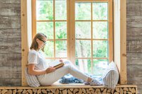 side-view-young-woman-sitting-window-sill-reading-book.jpg